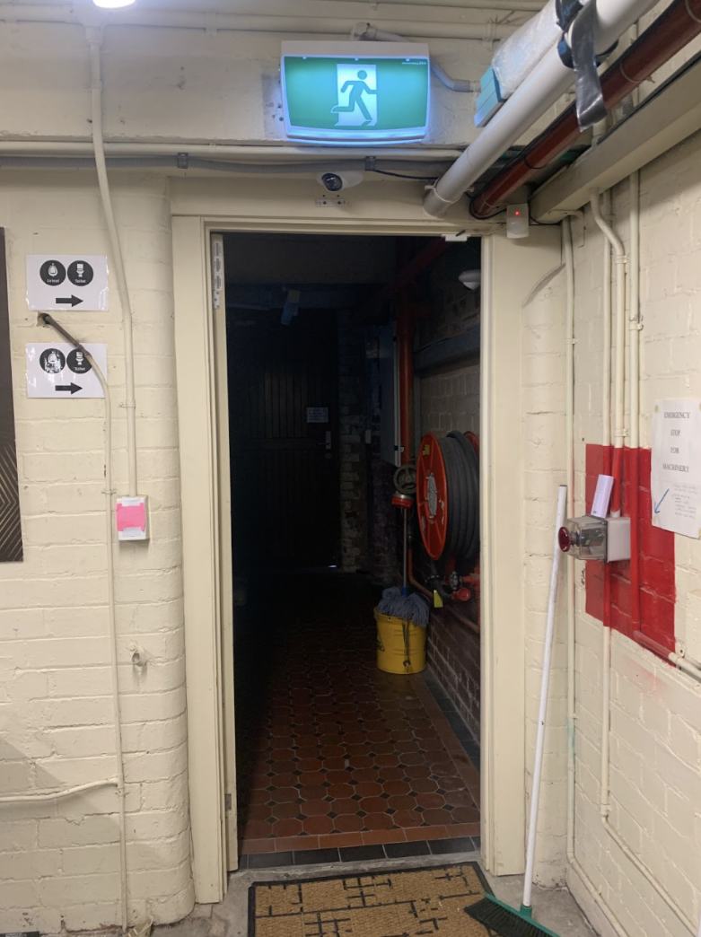 Image description: A photo showing the doorway from the workshop area to the hallway where the toilets are located.